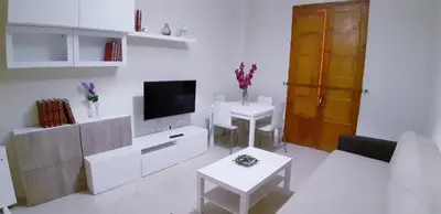 a white living room with two tables and a television at SAN JUSTO in Jerez de la Frontera