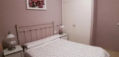 a bedroom with a bed and two tables and two lamps at SAN JUSTO in Jerez de la Frontera