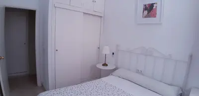 a white bedroom with a white bed and a lamp at SAN JUSTO in Jerez de la Frontera