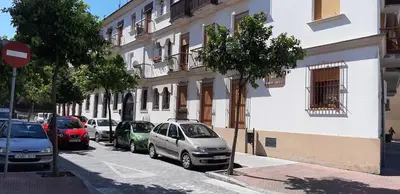 a row of cars parked on a street next to a building at SAN JUSTO in Jerez de la Frontera