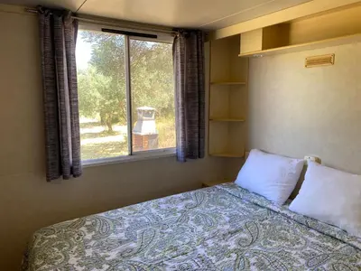 a bedroom with a bed and a window at The Farm Tiny House - Tiny Casa in Chiclana de la Frontera