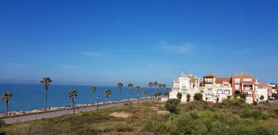a row of houses on a hill next to the ocean at Apartamentos Homing Puerto Sherry in El Puerto de Santa María