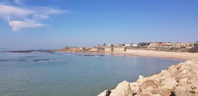 a view of a beach with rocks and a beach at Apartamentos Homing Puerto Sherry in El Puerto de Santa María