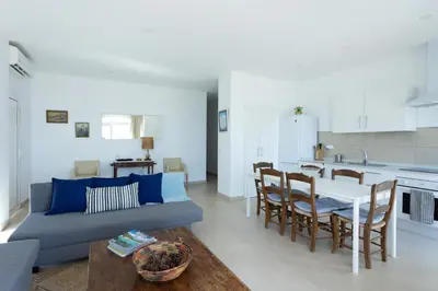 a living room with a couch and a table and a kitchen at Apartamentos Homing Puerto Sherry in El Puerto de Santa María