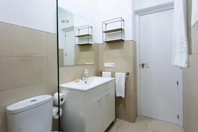 a bathroom with a toilet and a sink and a mirror at Apartamentos Homing Puerto Sherry in El Puerto de Santa María