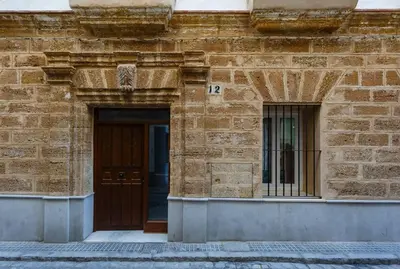 a brick building with a door with the number at SH Precioso Cruz. Acogedor y cerca del Mercado in Cádiz