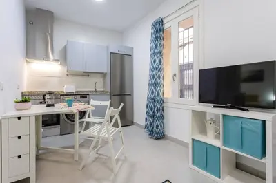 a kitchen with a table and a kitchen with blue cabinets at SH Precioso Cruz. Acogedor y cerca del Mercado in Cádiz