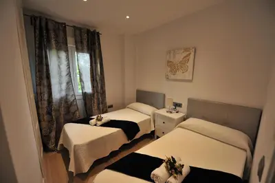 a room with three beds and a window at Diseño Terraza dos baños Piscina in Jerez de la Frontera