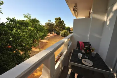 a table on a balcony with a view of a street at Diseño Terraza dos baños Piscina in Jerez de la Frontera