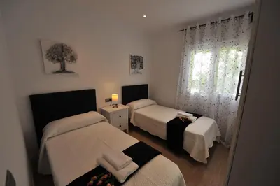 a small bedroom with two beds and a window at Diseño Terraza dos baños Piscina in Jerez de la Frontera