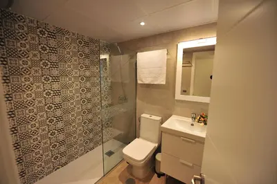 a bathroom with a toilet and a shower and a sink at Diseño Terraza dos baños Piscina in Jerez de la Frontera