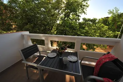 a balcony with a table and chairs on a deck at Diseño Terraza dos baños Piscina in Jerez de la Frontera