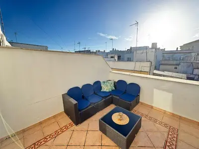 a couch sitting on a balcony on a roof at CDZ - Ático Tavira in Cádiz