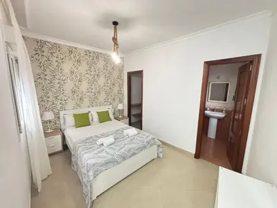 a white bedroom with a bed and a tv at CDZ - Ático Tavira in Cádiz