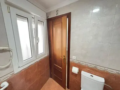 a bathroom with a toilet and a window and a door at CDZ - Ático Tavira in Cádiz