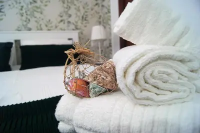 a bed with white towels and a basket on it at CDZ - Ático Tavira in Cádiz