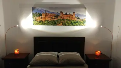 a bedroom with a bed with two lights on the wall at Apartamento Jerez Centro in Jerez de la Frontera