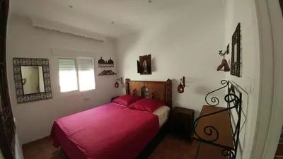 a bedroom with a bed with red sheets and a window at Apartamento Jerez Centro in Jerez de la Frontera