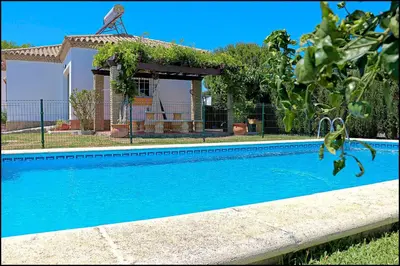 a swimming pool in front of a house at Bungalow Ramos III in Conil de la Frontera