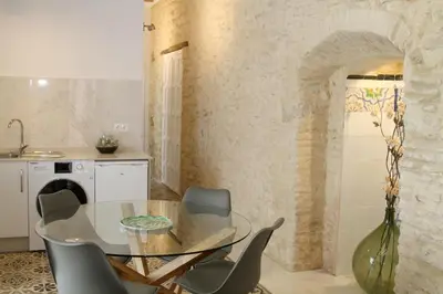 a dining room with a glass table and chairs at Casa Atahona - Casita con Encanto in Medina Sidonia