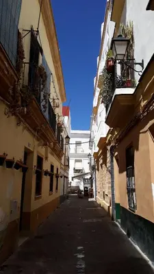 an alley between two buildings in a city at El Rincón del Tío de la Tiza in Cádiz