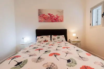 a bed with a comforter with umbrellas on it at Casa Comillas - Apartamento Doble in Cádiz