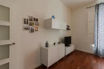 a living room with a tv and a white wall at Casa Comillas - Apartamento Doble in Cádiz