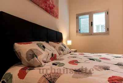 a bedroom with a bed with a bedspread with flowers at Casa Comillas - Apartamento Doble in Cádiz