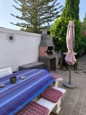 a patio with a bed and a grill and an umbrella at Villa Coral in Chiclana de la Frontera