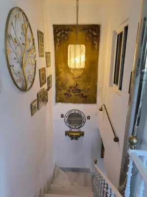 a hallway with stairs and a painting on the wall at Villa Coral in Chiclana de la Frontera