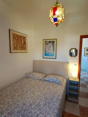 a bedroom with a bed and a chandelier at Villa Coral in Chiclana de la Frontera