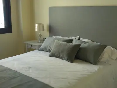 a white bed with four pillows on top of it at ARBOLÍ DREAMS in Cádiz