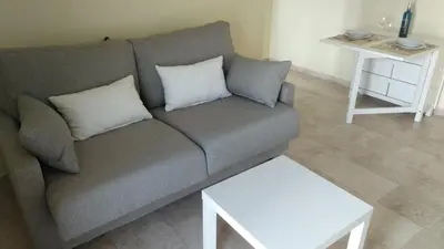 a living room with a couch and a table at ARBOLÍ DREAMS in Cádiz