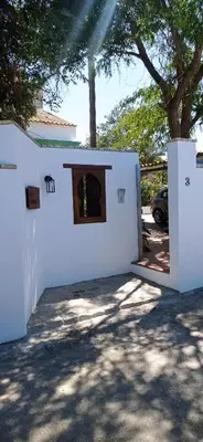 a white building with a door in a yard at La Luciérnaga in Chiclana de la Frontera