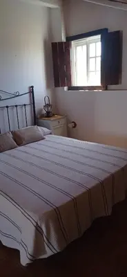 a bedroom with a large bed with a striped blanket at La Luciérnaga in Chiclana de la Frontera