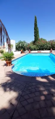 a large blue swimming pool in a yard at La Luciérnaga in Chiclana de la Frontera