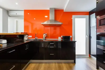a kitchen with a sink and an orange wall at ALTAMAR Sunny Home by Cadiz4Rentals in Cádiz