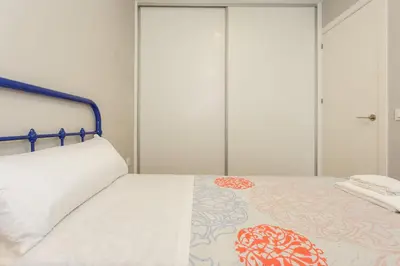 a bedroom with a white bed with a blue frame at ALTAMAR Sunny Home by Cadiz4Rentals in Cádiz
