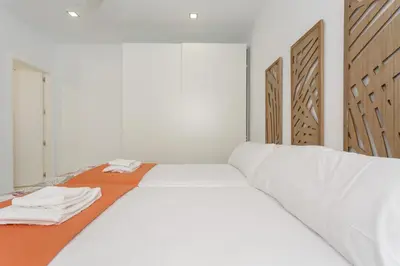 a white bed with white sheets and towels on it at Apartamento La Pepa de ORO by Cadiz4Rentals in Cádiz