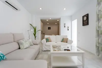 a white living room with a couch and a table at Apartamento La Pepa de ORO by Cadiz4Rentals in Cádiz