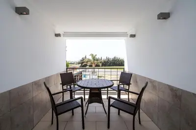 a kitchen with a sink and a living room at El Caseron de Conil & Spa in Conil de la Frontera