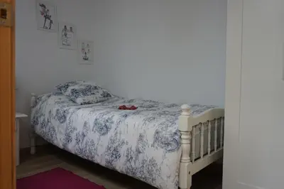 a bedroom with a bed with a blue and white comforter at Adosado en playa de la Barrosa, casa Carlota in Chiclana de la Frontera