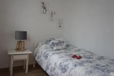 a bedroom with a bed and a table with a lamp at Adosado en playa de la Barrosa, casa Carlota in Chiclana de la Frontera