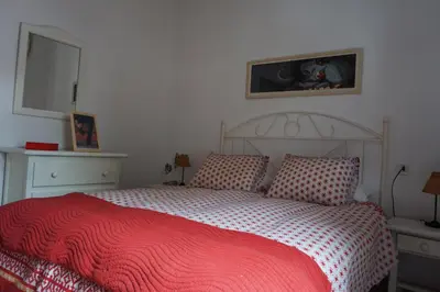 a bedroom with a bed with a red blanket at Adosado en playa de la Barrosa, casa Carlota in Chiclana de la Frontera