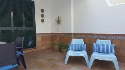 two white chairs and a tv in a room at Adosado en playa de la Barrosa, casa Carlota in Chiclana de la Frontera