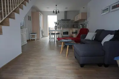 a living room with a couch and a table at Adosado en playa de la Barrosa, casa Carlota in Chiclana de la Frontera