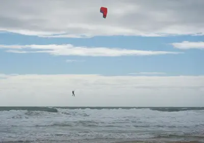 a person is flying a kite on the beach at Adosado en playa de la Barrosa, casa Carlota in Chiclana de la Frontera
