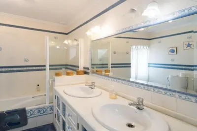 a bathroom with a sink and a mirror and a tub at Casa GaLuz, entre la Sierra y el Mar in Alcalá de los Gazules