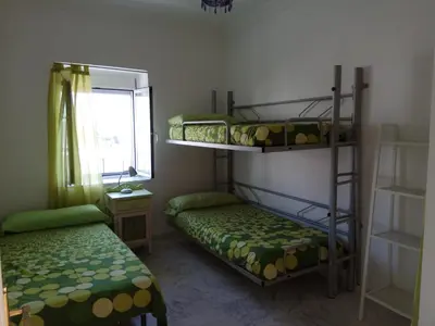 two bunk beds in a room with a window at Casa GaLuz, entre la Sierra y el Mar in Alcalá de los Gazules