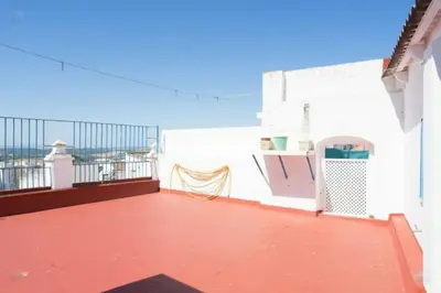 a balcony of a white building with a red floor at Casa GaLuz, entre la Sierra y el Mar in Alcalá de los Gazules